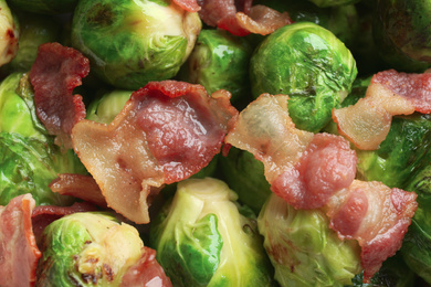 Photo of Delicious Brussels sprouts with bacon as background, closeup