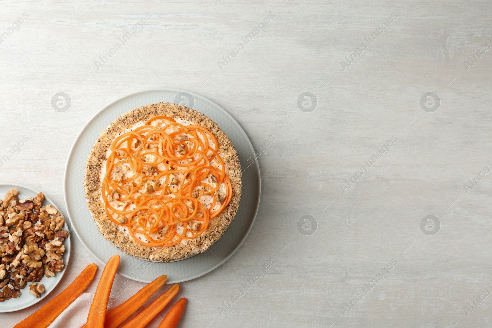 Photo of Flat lay composition with delicious carrot cake on light table, space for text