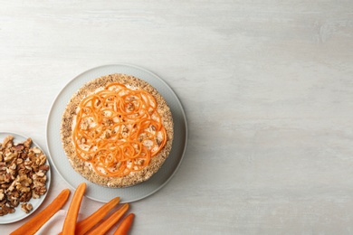 Flat lay composition with delicious carrot cake on light table, space for text