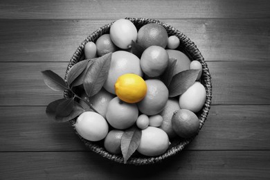 Different citrus fruits on wooden table, top view. Black and white tone with selective color effect