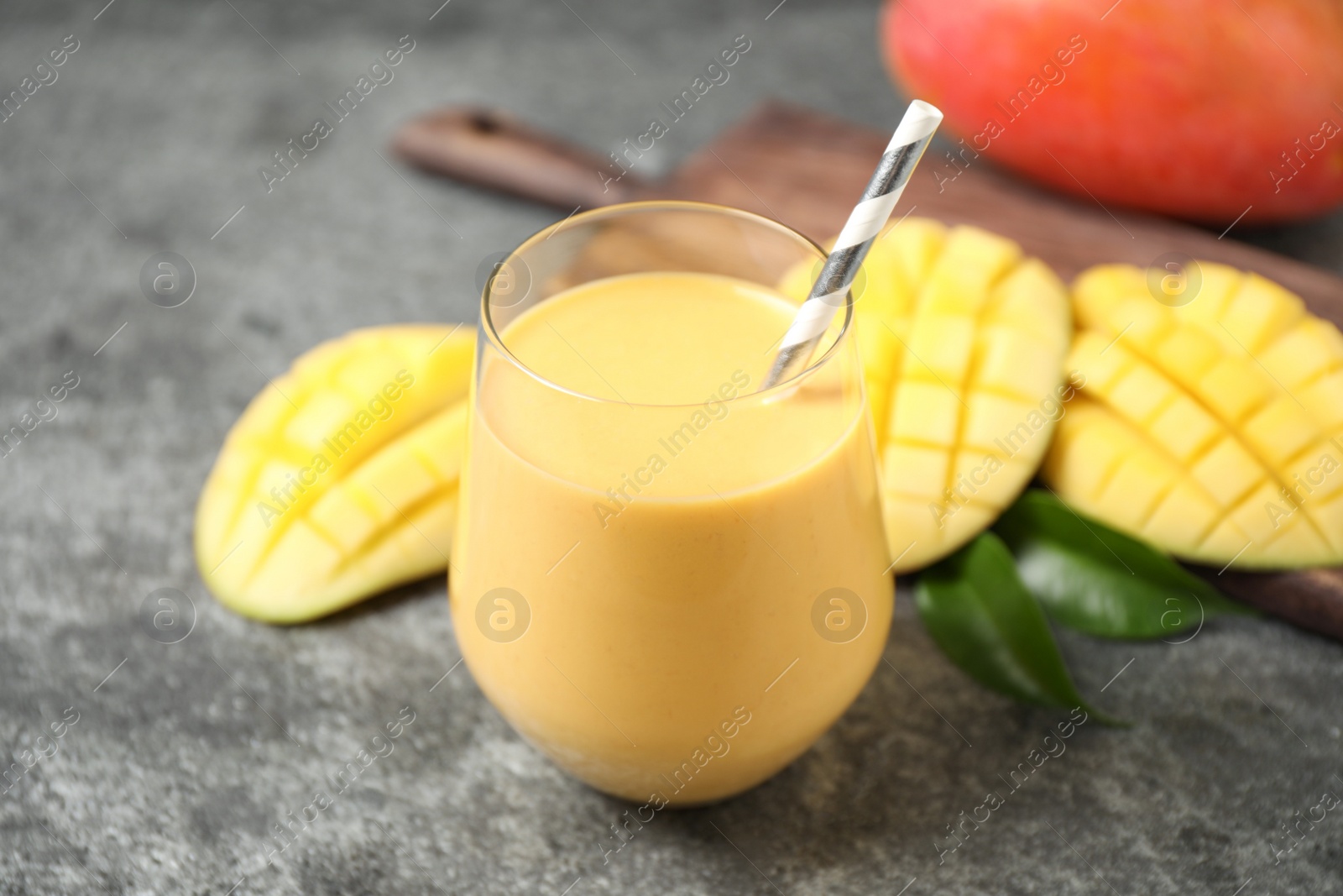 Photo of Fresh delicious mango drink on grey table