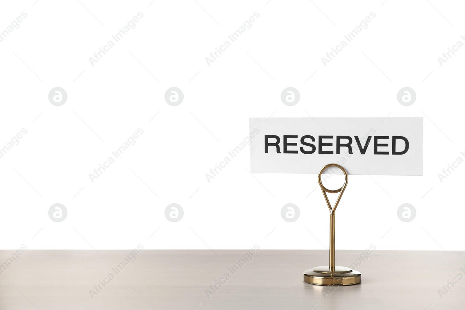 Photo of Elegant sign Reserved on wooden table against white background, space for text