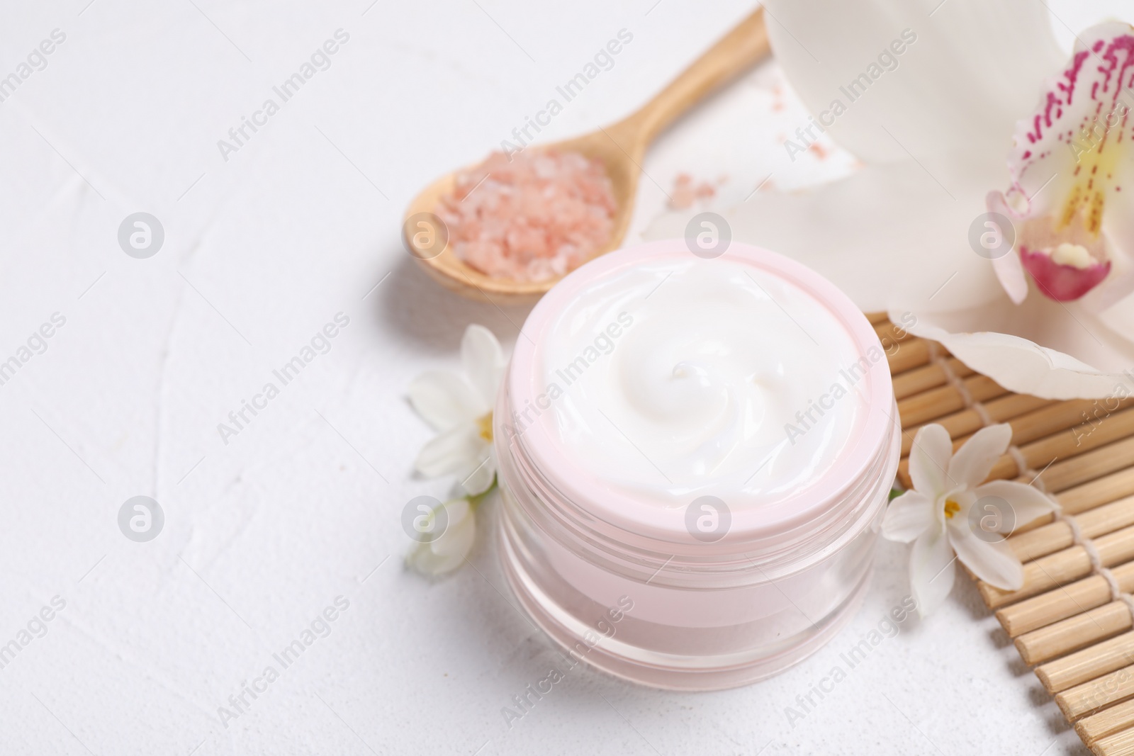 Photo of Beautiful spa composition with cosmetic products and flowers on white table. Space for text