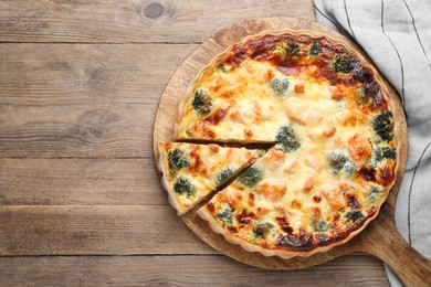 Delicious homemade quiche with salmon and broccoli on wooden table, top view. Space for text