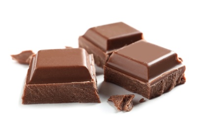 Photo of Pieces of tasty milk chocolate on white background