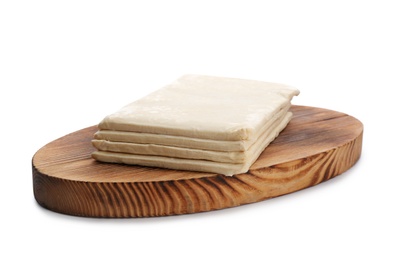 Photo of Wooden board with fresh dough on white background. Puff pastry