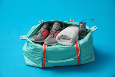 Photo of Sports bag with gym stuff on blue background