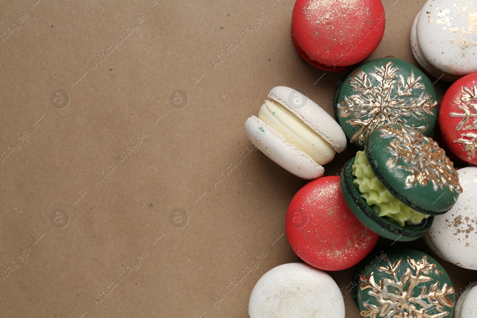 Photo of Beautifully decorated Christmas macarons on brown background, top view. Space for text