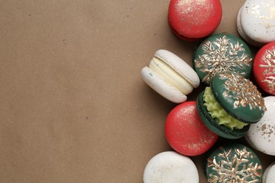 Beautifully decorated Christmas macarons on brown background, top view. Space for text