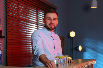 Photo of Bartender with shot glasses of Mexican Tequila at bar counter