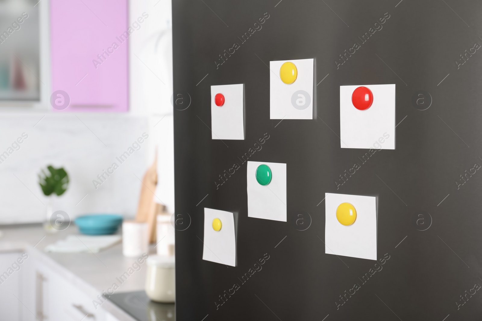 Photo of Blank paper notes and magnets on refrigerator door in kitchen