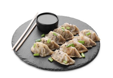Photo of Delicious gyoza (asian dumplings) with green onions, soy sauce and chopsticks on white table