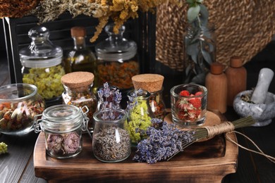 Photo of Many different herbs and dry lavender flowers on wooden table