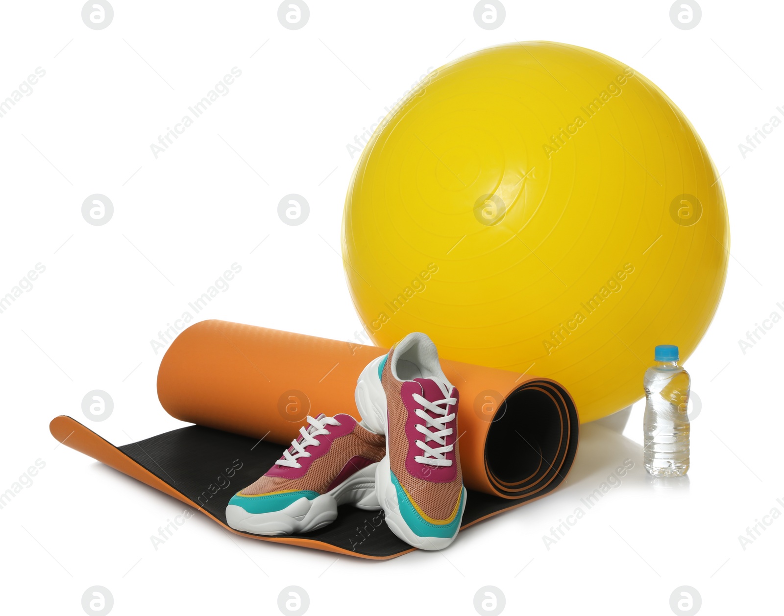 Photo of Fitness ball, yoga mat, bottle of water and sneakers isolated on white