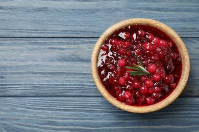 Fresh cranberry sauce on blue wooden table, top view. Space for text
