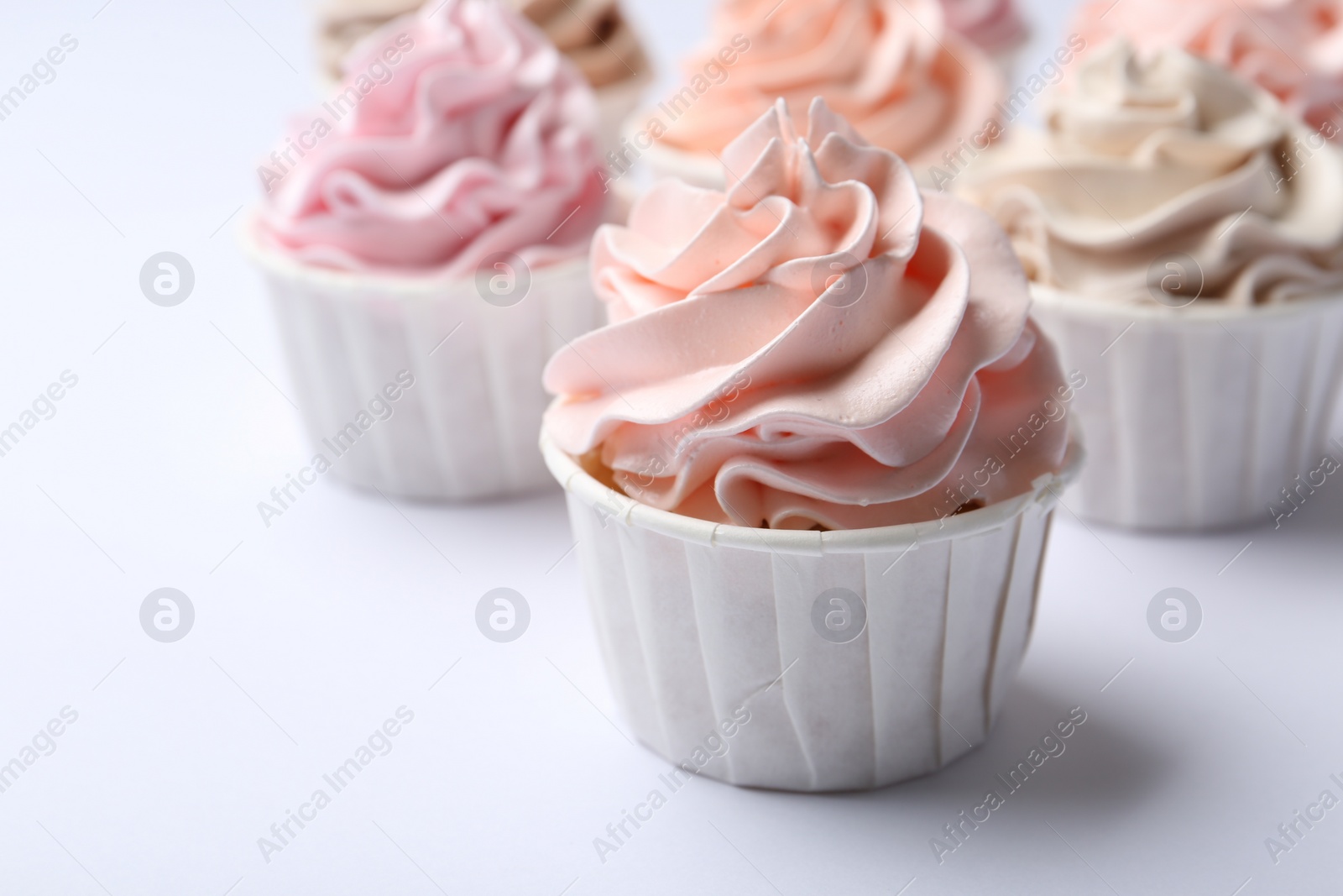 Photo of Many tasty cupcakes on white background, closeup