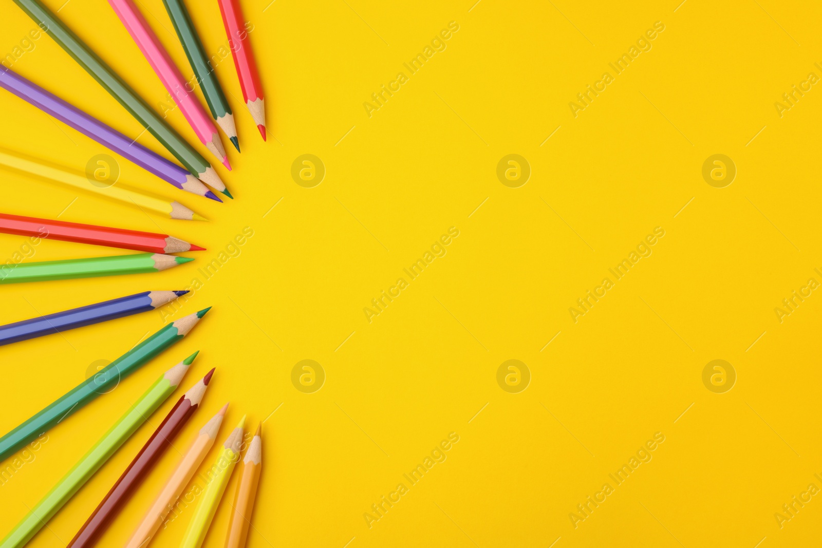 Photo of Colorful wooden pencils on yellow background, flat lay. Space for text