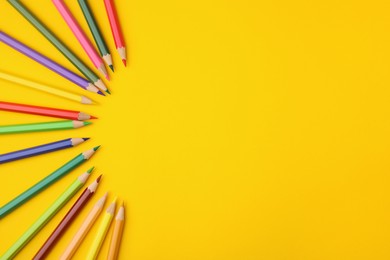 Photo of Colorful wooden pencils on yellow background, flat lay. Space for text