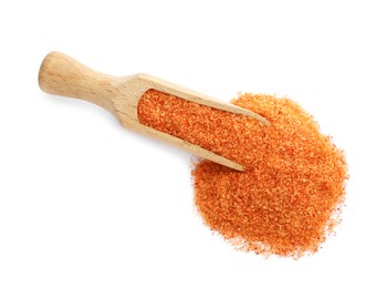 Photo of Wooden scoop with orange salt on white background, top view