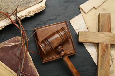 Judge gavel, wooden cross and crown of thorns on black table, flat lay