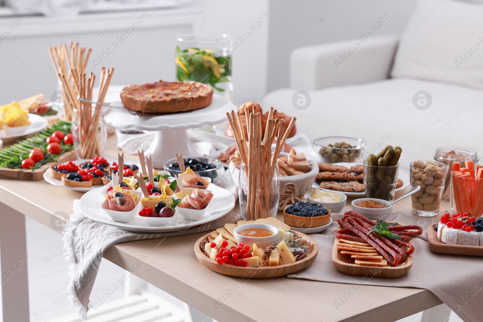 Photo of Dishes with different food on table in living room. Luxury brunch