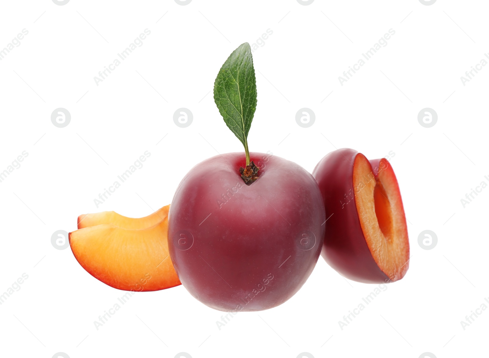 Photo of Whole and cut ripe plums with green leaf isolated on white