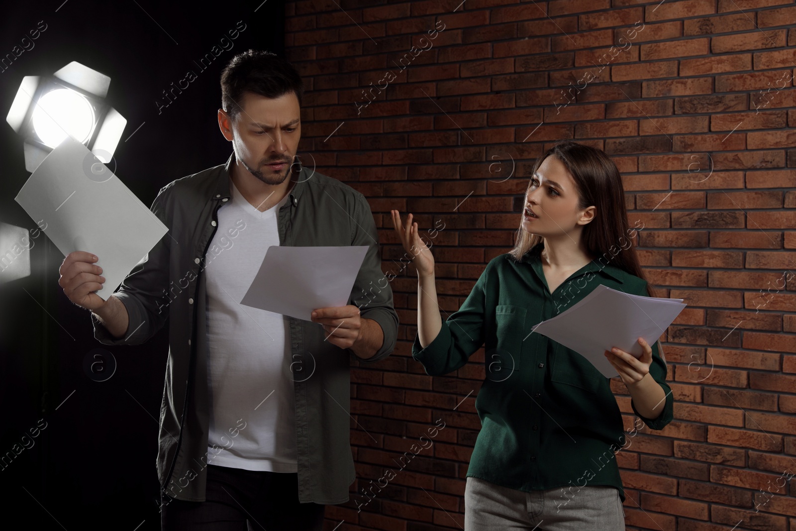 Photo of Professional actors reading their scripts during rehearsal in theatre