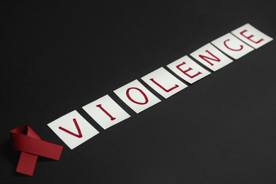 Purple ribbon and word VIOLENCE on black background