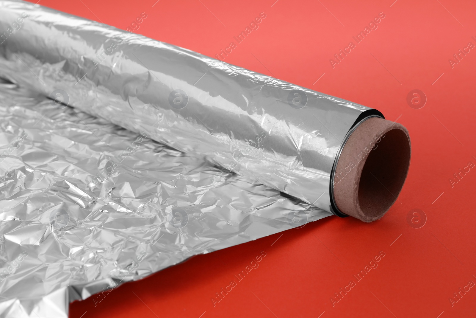 Photo of Roll of aluminum foil on orange background, closeup