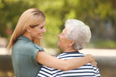 Photo of Woman with elderly mother outdoors on sunny day