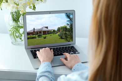 Image of Woman choosing new house online using laptop or real estate agent working at table, closeup