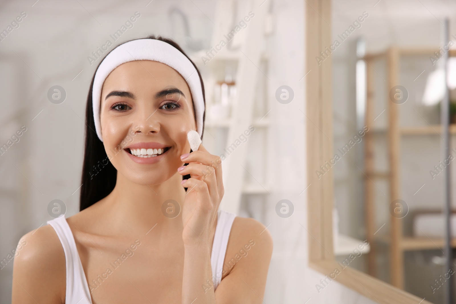 Photo of Woman using silkworm cocoon in skin care routine at home