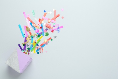 Colorful confetti and box on light background, top view. Space for text