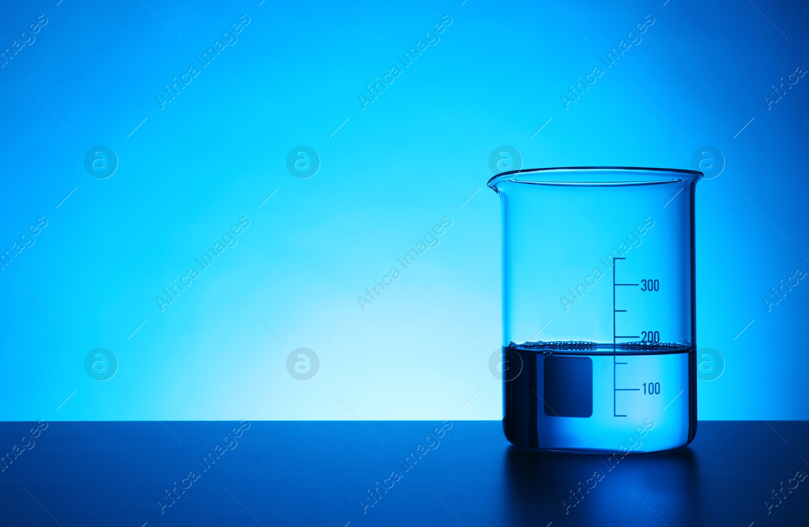 Photo of Empty beaker on table against color background. Chemistry laboratory glassware