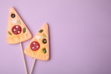 Photo of Pizza shaped lollipops on violet background, flat lay. Space for text