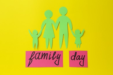 Photo of Cards with text Family Day and paper cutout on yellow background, flat lay