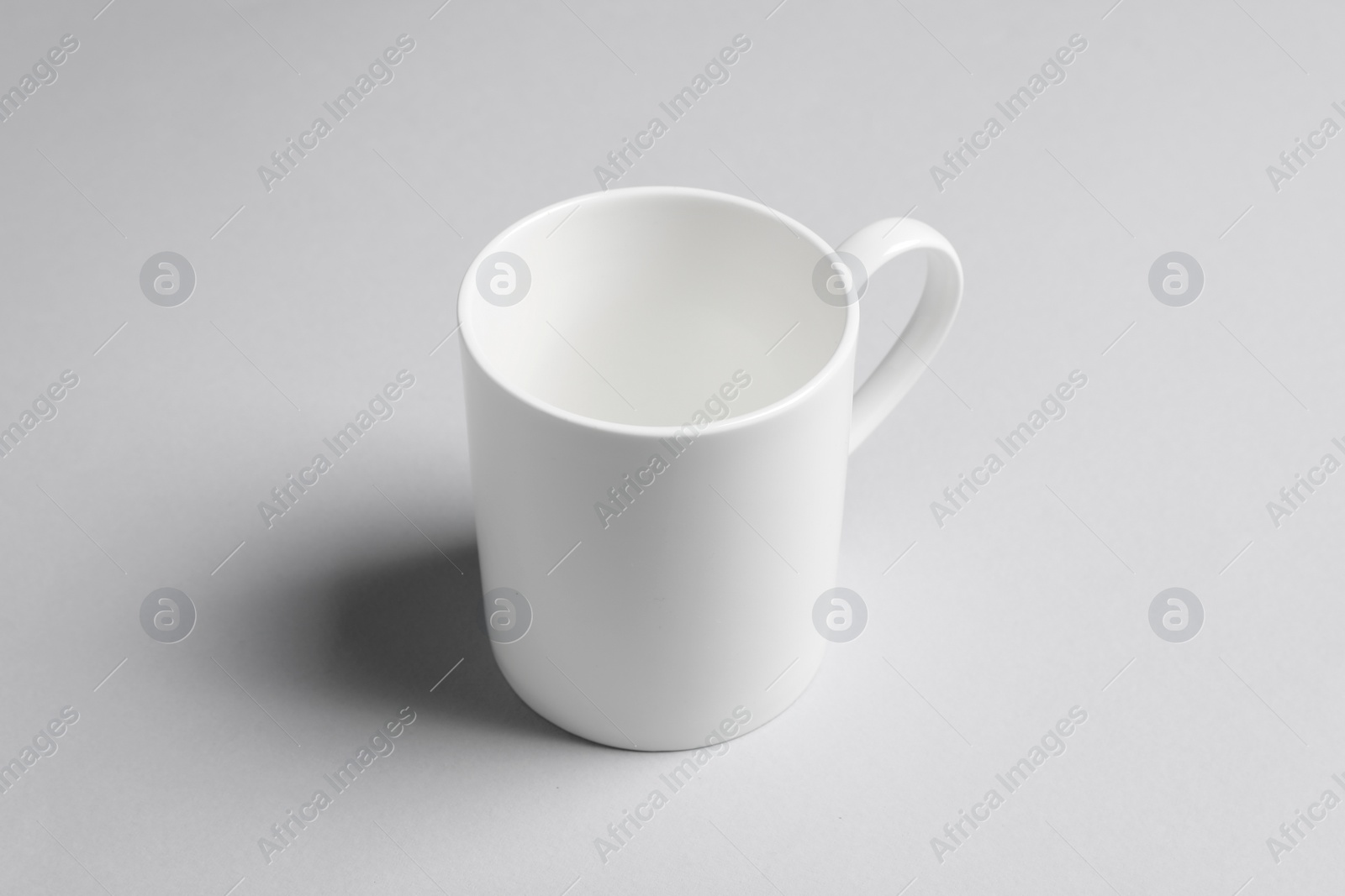 One white ceramic mug on light background Photo of One white ceramic mug on light background