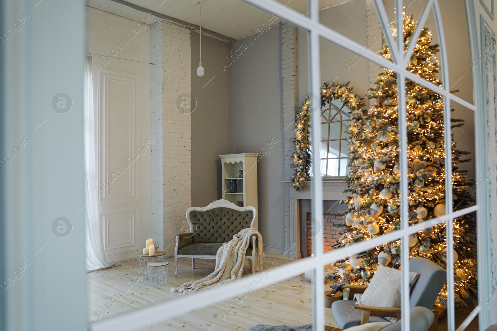 Photo of Festive room interior with stylish furniture and beautiful Christmas tree, view through window