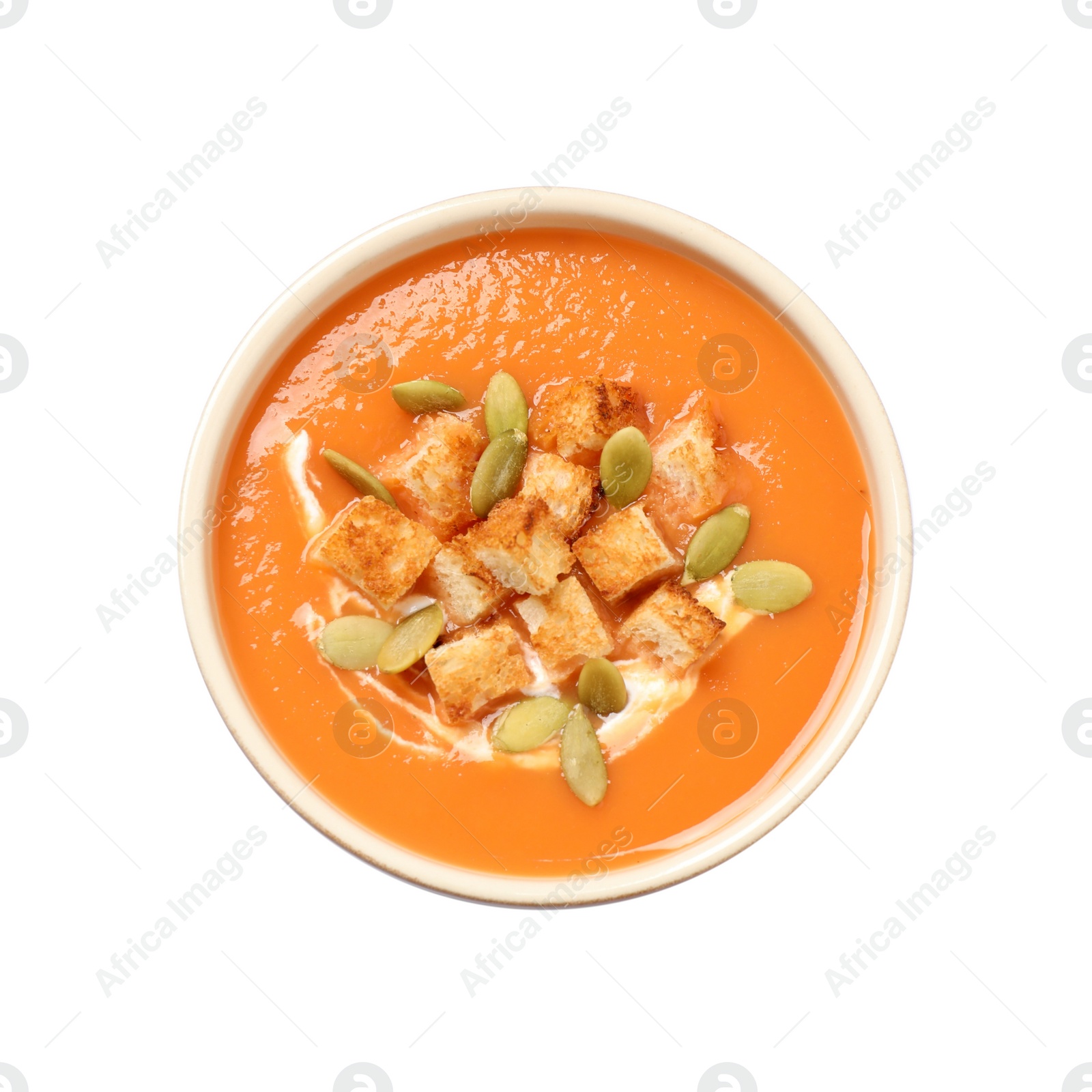 Photo of Tasty creamy pumpkin soup with croutons and seeds in bowl on white background, top view
