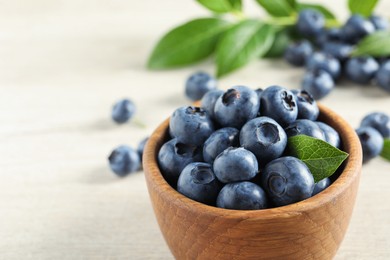 Photo of Bowl of fresh tasty blueberries on table, closeup. Space for text