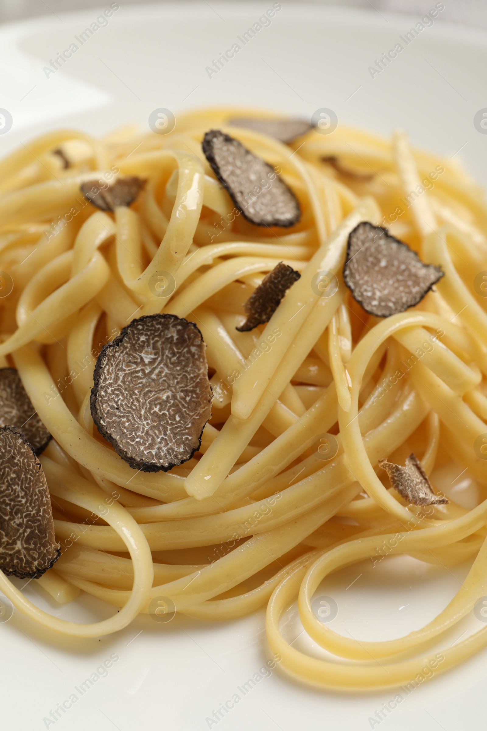 Photo of Tasty fettuccine with truffle on plate, closeup