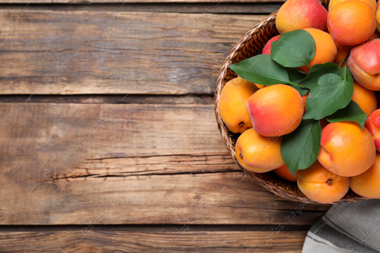 Photo of Delicious fresh ripe apricots on wooden table, top view. Space for text