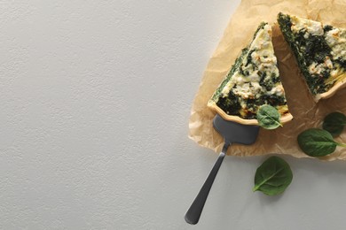 Photo of Delicious homemade spinach quiche on white table, flat lay. Space for text