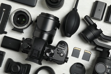 Flat lay composition with camera and video production equipment on light background