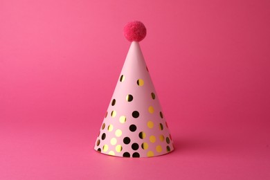 Photo of One beautiful party hat with pompom on pink background