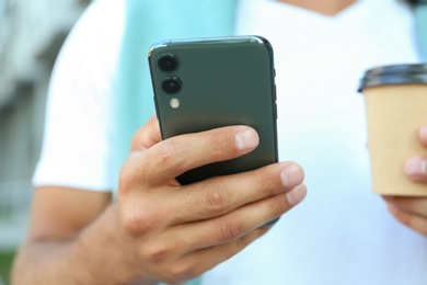 Man using modern mobile phone outdoors, closeup