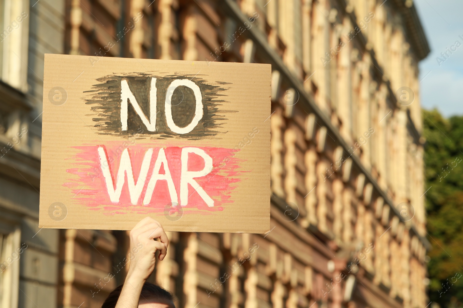 Photo of Woman holding poster with words No War outdoors. Space for text