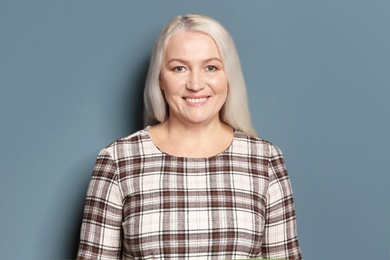 Portrait of beautiful mature woman on color background