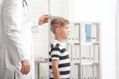 Photo of Doctor measuring little boy's height in hospital