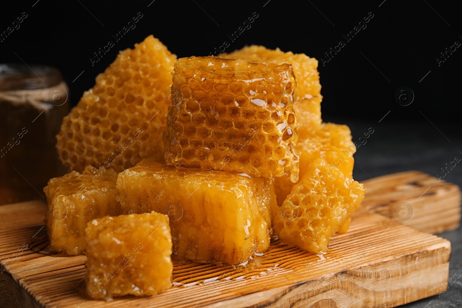 Photo of Fresh delicious sweet honeycombs on wooden board, closeup